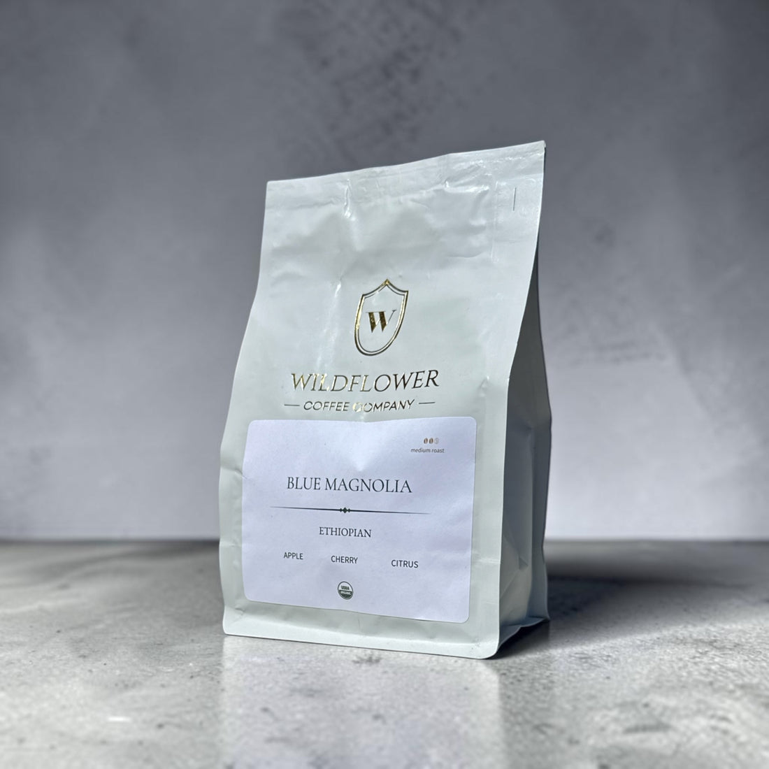 White coffee bag with 'Wildflower Coffee Company' logo on a gray background